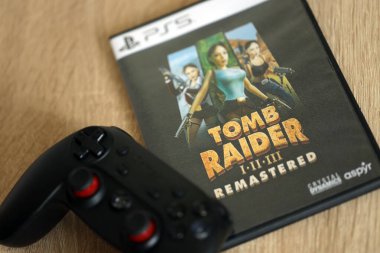 KYIV, UKRAINE - JUNE 26, 2024 Tomb Raider 1-2-3 Remastered PS5 video game disc box for console gaming. Popular video game disc close up clipart