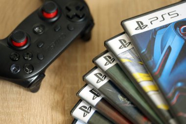 KYIV, UKRAINE - 26 Haziran 2024 Sony Playstation 5 ve 4 konsolu için video oyunları yığını. Birçok popüler video oyunu disk kutusu kapanıyor