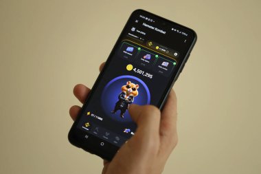 KYIV, UKRAINE - 26 Haziran 2024 Hamster Kombat mini telgraf oyunu. Akıllı telefondaki tıkırtı oyunu elinizin altında