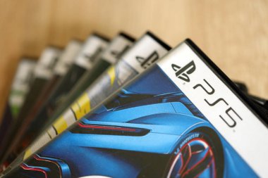 KYIV, UKRAINE - 26 Haziran 2024 Sony Playstation 5 ve 4 konsolu için video oyunları yığını. Birçok popüler video oyunu disk kutusu kapanıyor