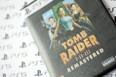 KYIV, UKRAINE - 26 Haziran 2024 Tomb Raider 1-2-3 Konsol oyunu için PS5 oyun diski kutusunda ustalaştı. Popüler video oyunu diski kapat