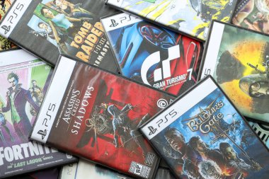 KYIV, UKRAINE - 26 Haziran 2024 Sony Playstation 5 ve 4 konsolu için video oyunları yığını. Birçok popüler video oyunu disk kutusu kapanıyor