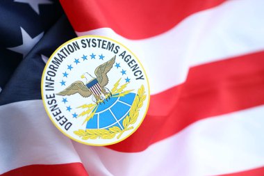 KYIV, UKRAINE - 26 Haziran 2024 Savunma Bilgi Sistemleri Ajansı arması ABD bayrağının üzerine yapıştırma yapıştırması