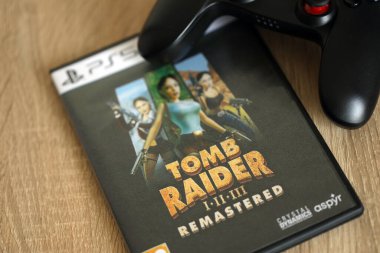 KYIV, UKRAINE - 26 Haziran 2024 Tomb Raider 1-2-3 Konsol oyunu için PS5 oyun diski kutusunda ustalaştı. Popüler video oyunu diski kapat
