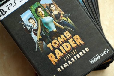 KYIV, UKRAINE - 26 Haziran 2024 Tomb Raider 1-2-3 Konsol oyunu için PS5 oyun diski kutusunda ustalaştı. Popüler video oyunu diski kapat