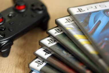 KYIV, UKRAINE - 26 Haziran 2024 Sony Playstation 5 ve 4 konsolu için video oyunları yığını. Birçok popüler video oyunu disk kutusu kapanıyor
