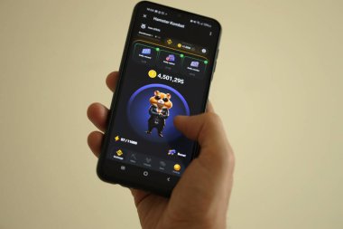 KYIV, UKRAINE - 26 Haziran 2024 Hamster Kombat mini telgraf oyunu. Akıllı telefondaki tıkırtı oyunu elinizin altında