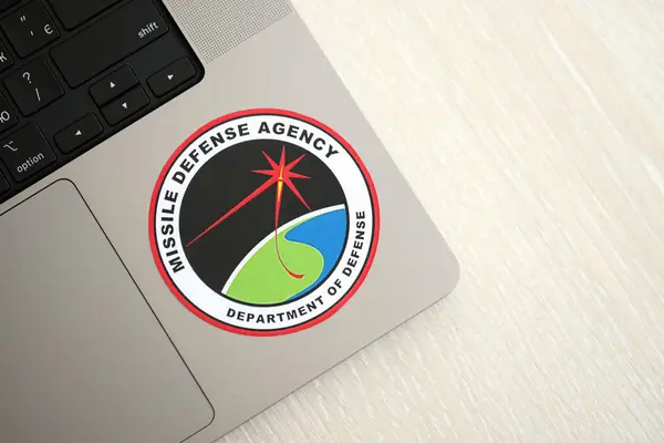 stock image KYIV, UKRAINE - JUNE 26, 2024 Department of Defense Missile Defense Agency coat of arms sticker on silver laptop close up