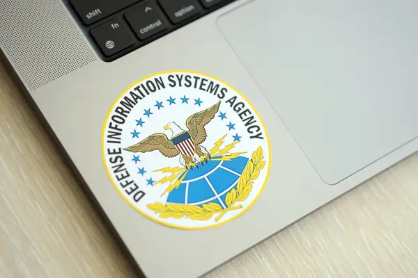 stock image KYIV, UKRAINE - JUNE 26, 2024 Defense Information Systems Agency coat of arms sticker on silver laptop close up