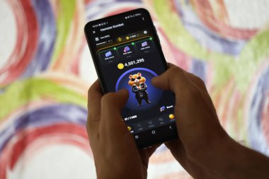 KYIV, UKRAINE - 26 Haziran 2024 Hamster Kombat mini telgraf oyunu. Akıllı telefondaki tıkırtı oyunu elinizin altında