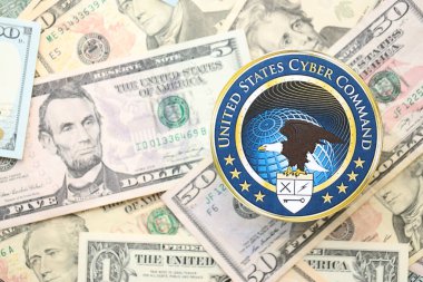 KYIV, UKRAINE - 26 Haziran 2024 Birleşik Devletler Siber Komuta Arması büyük miktarda Amerikan doları banknotlar kapalı