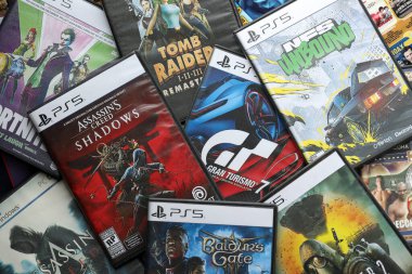 KYIV, UKRAINE - 26 Haziran 2024 Sony Playstation 5 ve 4 konsolu için video oyunları yığını. Birçok popüler video oyunu disk kutusu kapanıyor