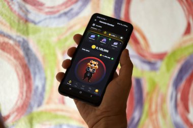 KYIV, UKRAINE - 26 Haziran 2024 Hamster Kombat mini telgraf oyunu. Akıllı telefondaki tıkırtı oyunu elinizin altında