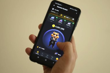 KYIV, UKRAINE - 26 Haziran 2024 Hamster Kombat mini telgraf oyunu. Akıllı telefondaki tıkırtı oyunu elinizin altında