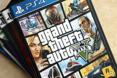 KYIV, UKRAINE - JUNE 26, 2024 Grand Theft Auto 5 PS4 video game disc box for console gaming. Popular video game disc close up clipart