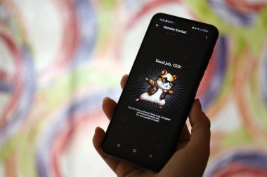 KYIV, UKRAINE - 26 Haziran 2024 Hamster Kombat mini telgraf oyunu. Akıllı telefondaki tıkırtı oyunu elinizin altında