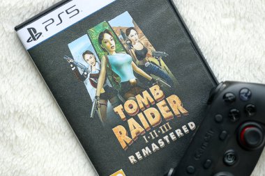 KYIV, UKRAINE - 26 Haziran 2024 Tomb Raider 1-2-3 Konsol oyunu için PS5 oyun diski kutusunda ustalaştı. Popüler video oyunu diski kapat