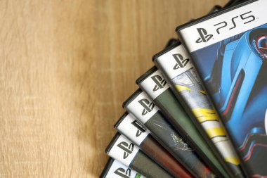 KYIV, UKRAINE - 26 Haziran 2024 Sony Playstation 5 ve 4 konsolu için video oyunları yığını. Birçok popüler video oyunu disk kutusu kapanıyor