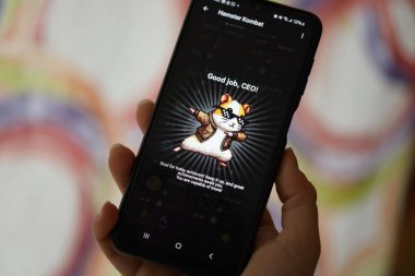 KYIV, UKRAINE - 26 Haziran 2024 Hamster Kombat mini telgraf oyunu. Akıllı telefondaki tıkırtı oyunu elinizin altında