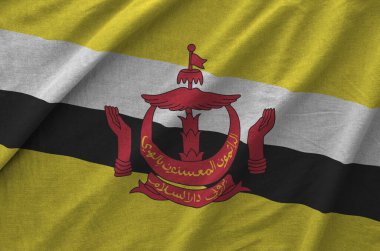 Brunei Darussalam flag depicted on folded wavy fabric of old cloth close up clipart