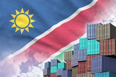 Namibya bayrağı ve yükleme konteynırları rıhtımlarda, arka planda gökyüzü kapalı.