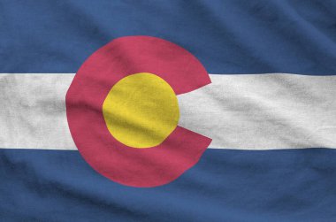 Colorado US state flag depicted on folded wavy fabric of old cloth close up clipart