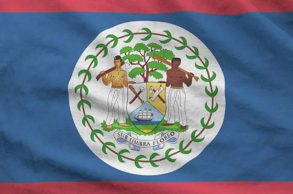 Stock image Belize flag depicted on folded wavy fabric of old cloth close up