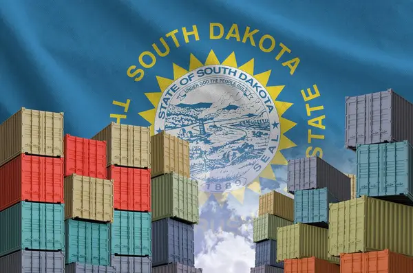 stock image South Dakota US state flag and big stack of shipping cargo containers in docks with sky background close up
