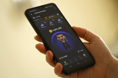 KYIV, UKRAINE - 26 Haziran 2024 Hamster Kombat mini telgraf oyunu. Akıllı telefondaki tıkırtı oyunu elinizin altında