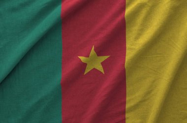 Cameroon flag depicted on folded wavy fabric of old cloth close up clipart