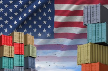 Amerika Birleşik Devletleri bayrağı ve yükleme konteynırları rıhtımlarda ve gökyüzü arka planında yakın çekim