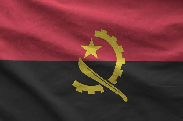 stock image Angola flag depicted on folded wavy fabric of old cloth close up