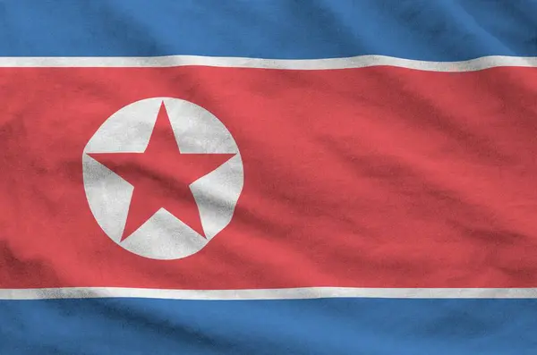 stock image North Korea flag depicted on folded wavy fabric of old cloth close up