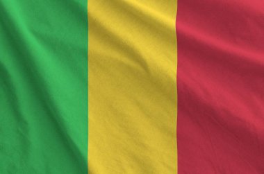 Mali flag depicted on folded wavy fabric of old cloth close up clipart