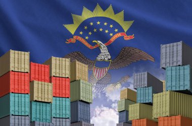 North Dakota US state flag and big stack of shipping cargo containers in docks with sky background close up clipart