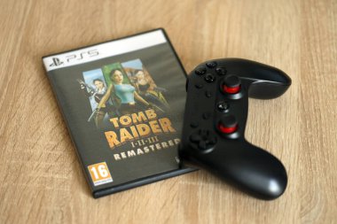 KYIV, UKRAINE - 26 Haziran 2024 Tomb Raider 1-2-3 Konsol oyunu için PS5 oyun diski kutusunda ustalaştı. Popüler video oyunu diski kapat