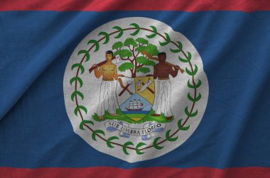 Belize flag depicted on folded wavy fabric of old cloth close up clipart