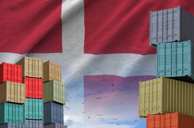 Denmark flag and big stack of shipping cargo containers in docks with sky background close up clipart