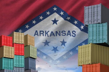 Arkansas US state flag and big stack of shipping cargo containers in docks with sky background close up