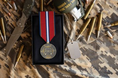 KYIV, UKRAINE - 10 Temmuz 2024 ABD Sahil Güvenlik iyi hal madalyası. Birleşik Devletler askeri madalyası, kurdele ve broşla. El yapımı kağıt tiyatro dekorları yakın plan.