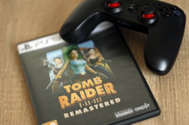 KYIV, UKRAINE - 26 Haziran 2024 Tomb Raider 1-2-3 Konsol oyunu için PS5 oyun diski kutusunda ustalaştı. Popüler video oyunu diski kapat