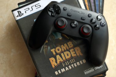 KYIV, UKRAINE - 26 Haziran 2024 Tomb Raider 1-2-3 Konsol oyunu için PS5 oyun diski kutusunda ustalaştı. Popüler video oyunu diski kapat