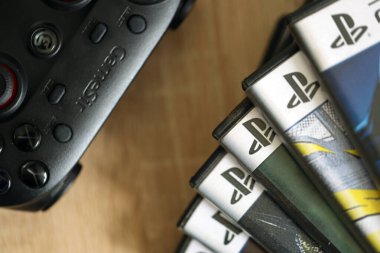 KYIV, UKRAINE - 26 Haziran 2024 Sony Playstation 5 ve 4 konsolu için video oyunları yığını. Birçok popüler video oyunu disk kutusu kapanıyor