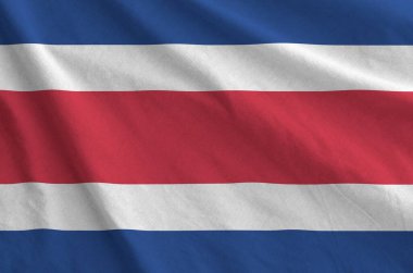 Costa Rica flag depicted on folded wavy fabric of old cloth close up clipart