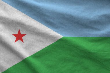 Djibouti flag depicted on folded wavy fabric of old cloth close up clipart