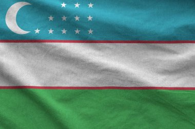 Özbekistan bayrağı eski kumaşların katlanmış dalgalı kumaşında tasvir edilmiştir.