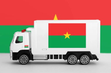 Burkina Faso flag depicted on side wall of white delivery van close up. Shipping and local delivery concept clipart