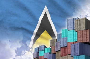 Saint Lucia flag and big stack of shipping cargo containers in docks with sky background close up clipart