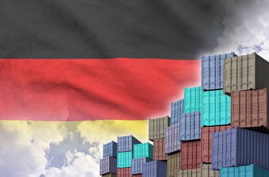 Almanya bayrağı ve rıhtımlarda arka planda bulunan büyük kargo konteynırları.