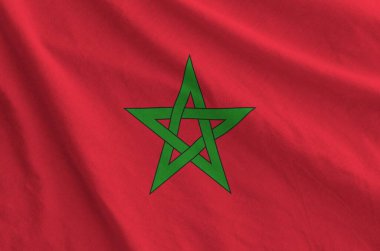 Eski kumaştan katlanmış dalgalı kumaş üzerinde Fas bayrağı tasvir edilmiştir.